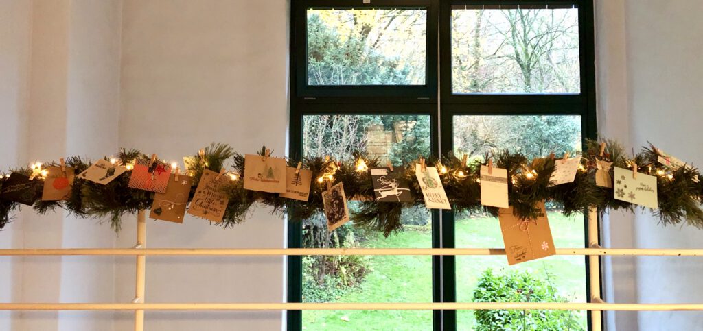 Handgemachte ATCs als Adventskalender an einer beleuchteten Tannengirlande